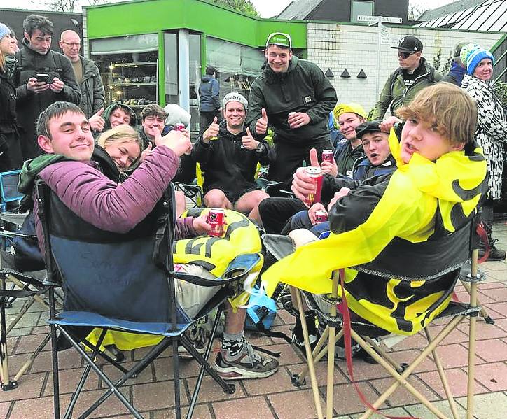 Un grupo de aficionados disfruta de la carrera y la cerveza.