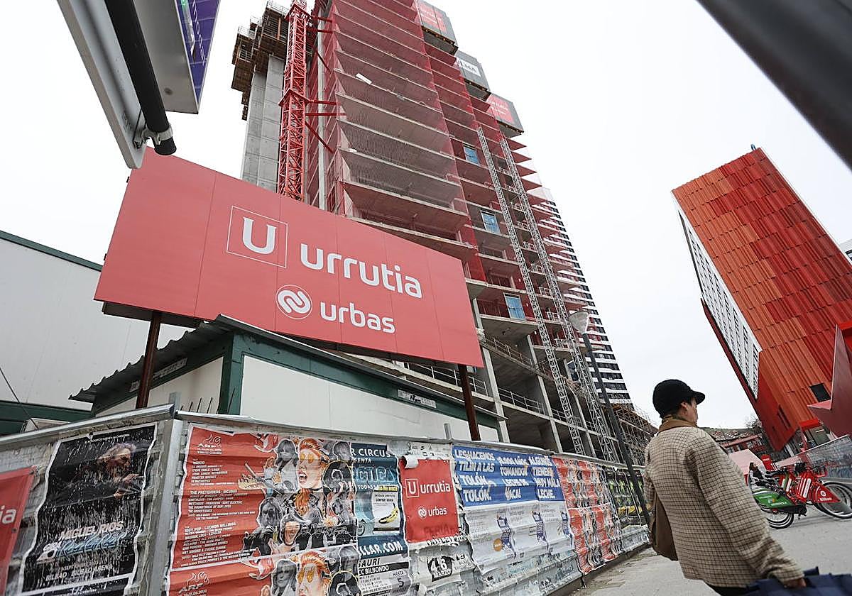 Una mujer pasa frente a la obra de la quinta torre de Garellano.