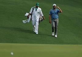 Jon Rahm y su caddie examinan el recorrido.