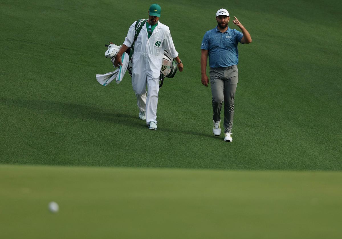 Jon Rahm y su caddie examinan el recorrido.