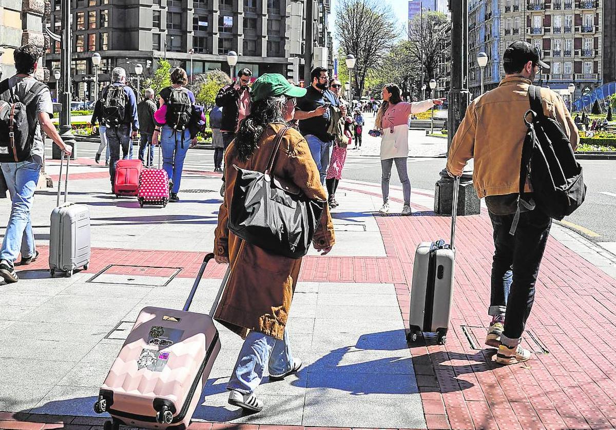 Turistas con sus maletas en la Plaza Moyúa.