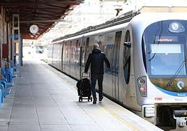 Un pasajero camina por el andén para subirse a una unidad de Euskotren de la serie 900, fabricada or CAF.