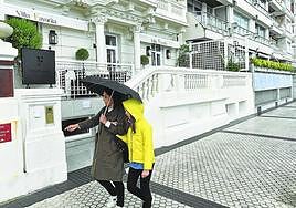 Una mujer y una niña pasean por delante del restaurante, con dos estrellas Michelin.