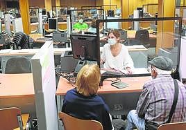 Una funcionaria atiende a dos contribuyentes en una campaña de la Renta anterior.