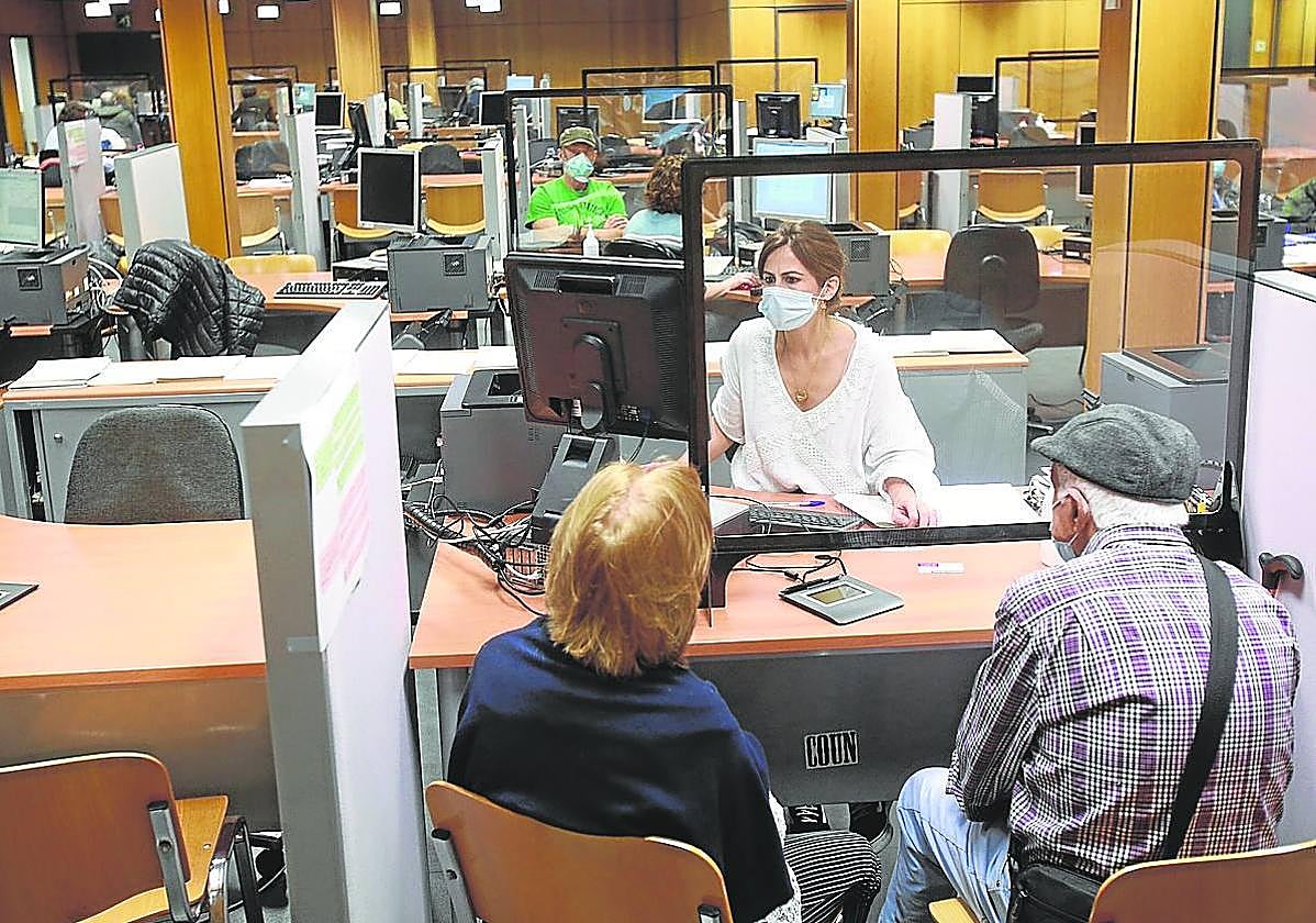 Una funcionaria atiende a dos contribuyentes en una campaña de la Renta anterior.