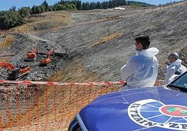 Control. Dos ertzainas graban el trabajo de excavación.