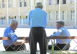 Varios jubilados charlan en una plaza.