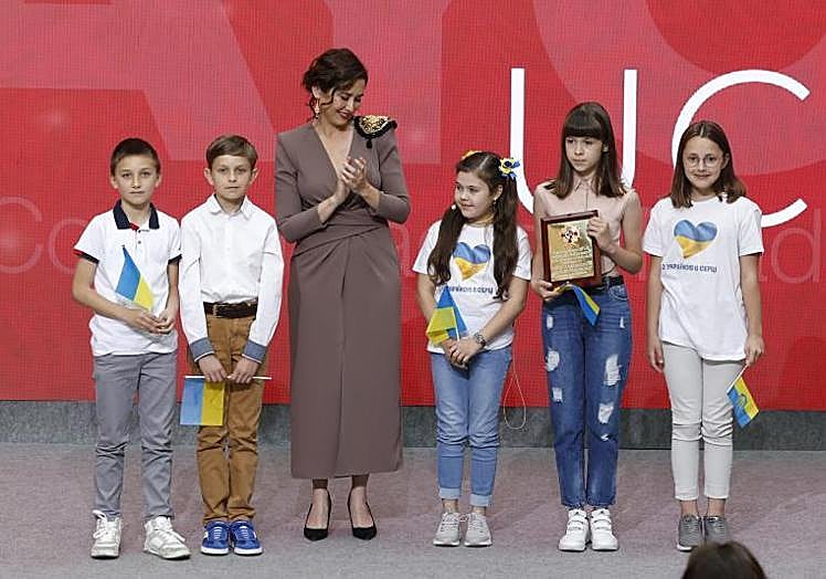 Imagen principal - sabel Díaz Ayuso, con varios niños ucranianos, y con Koke, futbolista del Atlético de Madrid