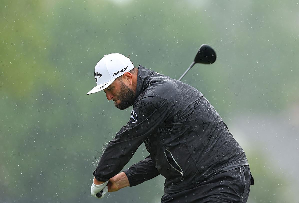 Rahm se dispone a golpear a la bola bajo la lluvia.