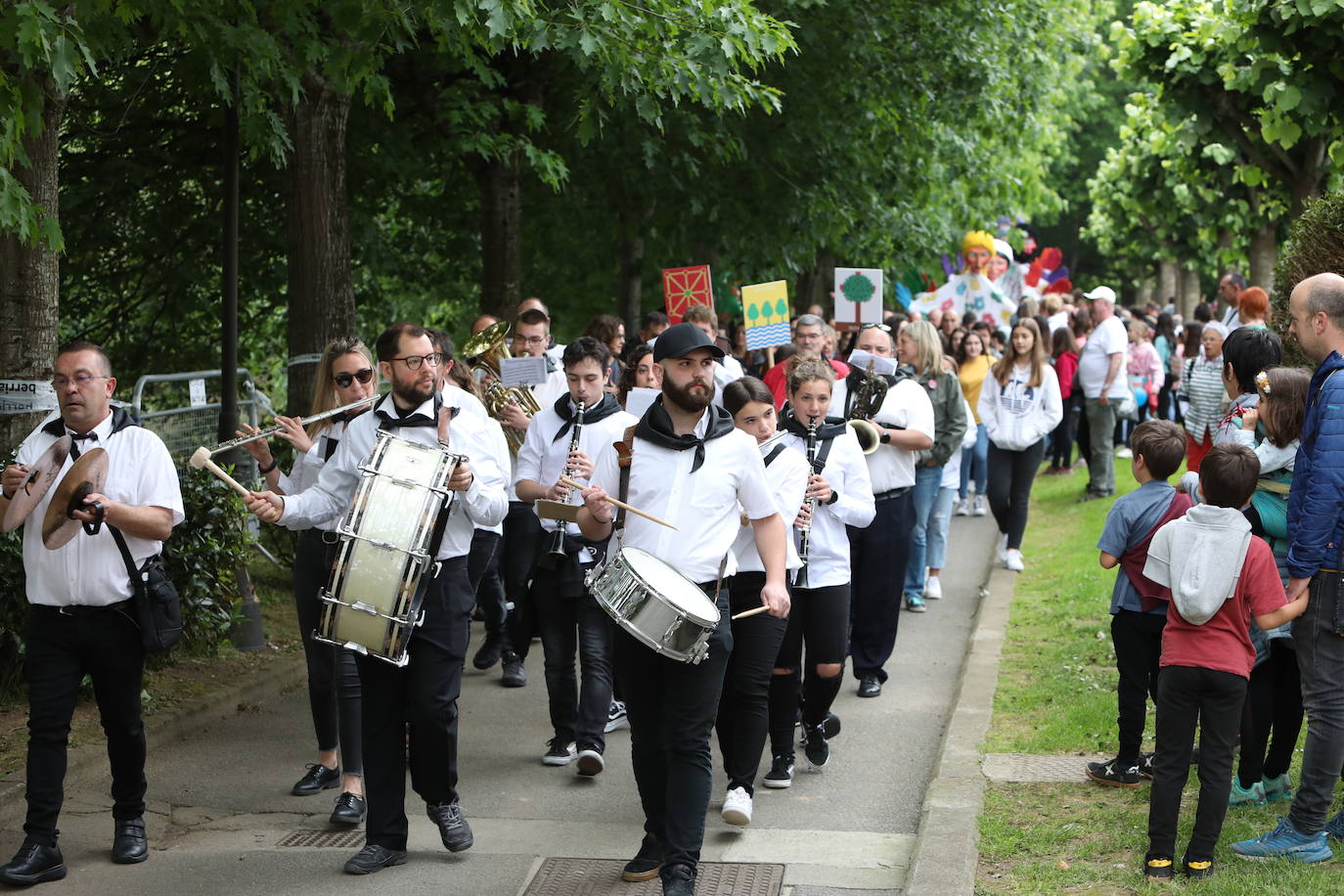 Ibilaldira hurbildu diren pertsona batzuk, ibilbidea egiten, musikari batzuk jotzen duten bitartean.