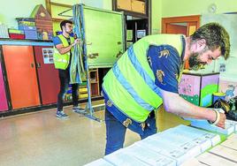 Dos funcionarios preparan las papeletas en el colegio público de Uribarri.