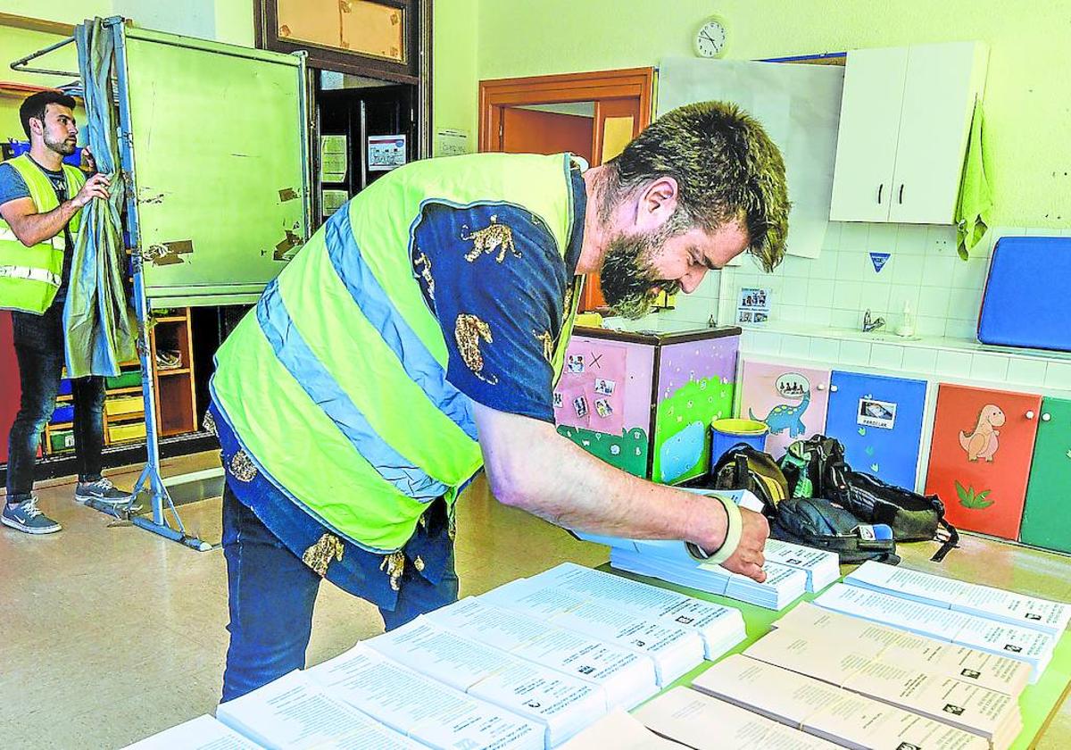 Dos funcionarios preparan las papeletas en el colegio público de Uribarri.