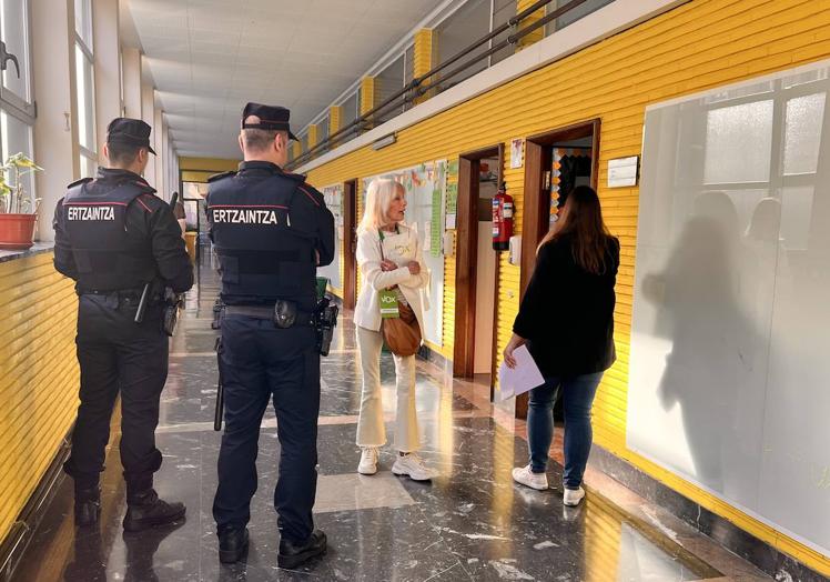 Imagen principal - Arriba, ertzainas vigilan un aula en la que no se lograban cubrir los puestos; en la imagen central, suplentes legando a primera hora para conocer si pueden marcharse o deben quedarse, y abajo, uno de ellos, Álex de Benito celebra que ha podido regresar a casa.