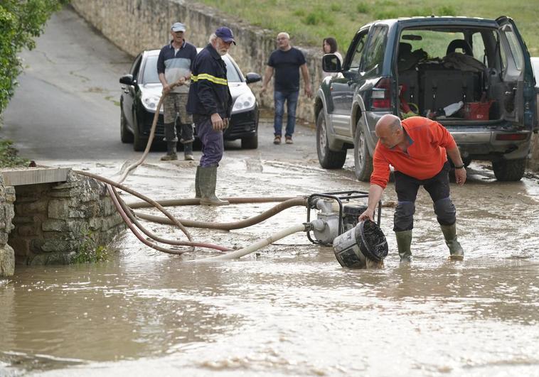 Los vecinos de Fontecha tratan de achicar la riada con una bomba de agua.