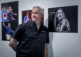 Stuart MacDonald, conocido como MusicSnapper, posa en la Casa de Cultura Ignacio Aldecoa junto a algunas de sus instantáneas.