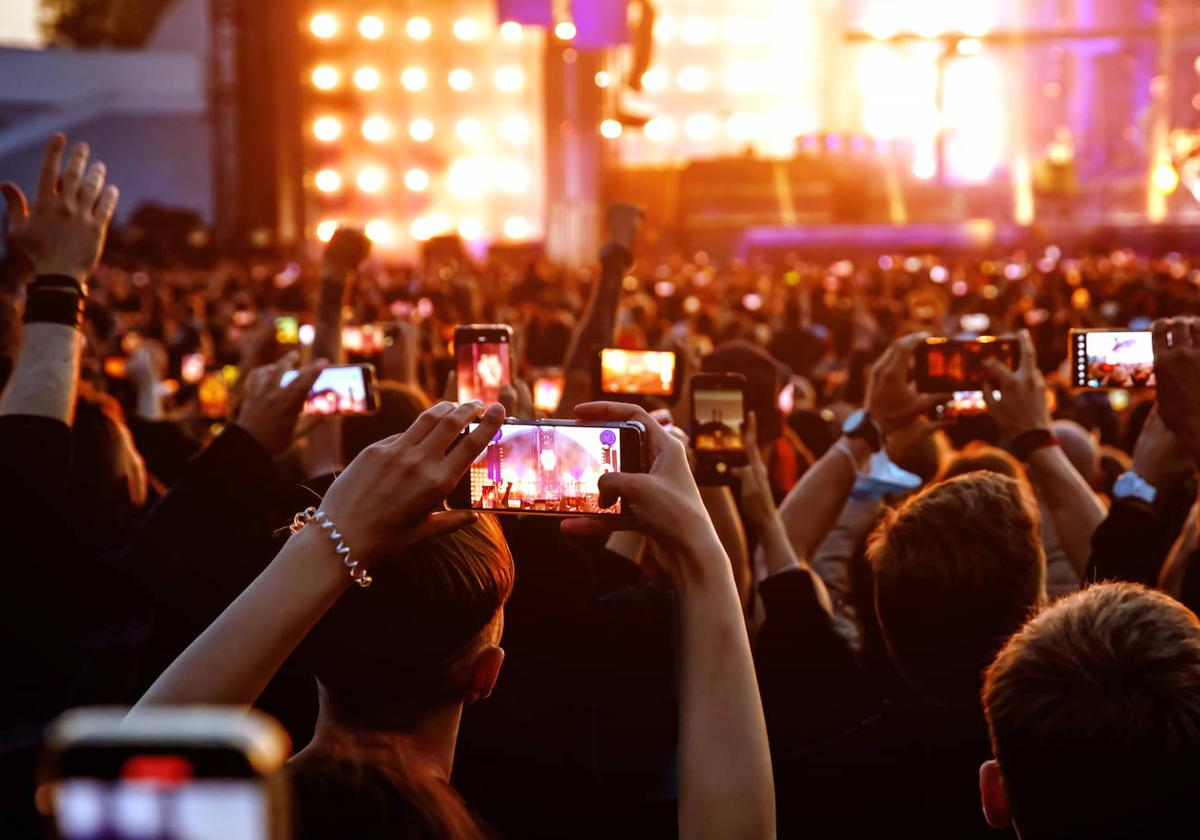 El público captura con sus móviles una actuación en un festival.