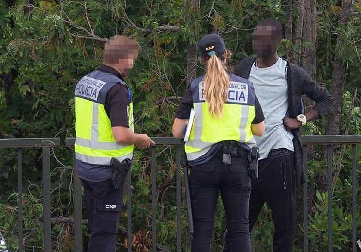 Dos agentes identifican a un inmigrante en la muga.