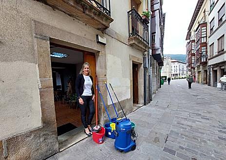 Imagen secundaria 1 - Colocando una tabla en el bar Narú para evitar otra inundación. Cubos y fregonas en la notaría Gestión 10 y la peluquería Rabatt, donde entró un palmo de agua. 
