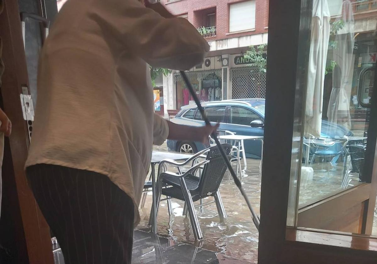 Un hostelero de Galdakao achica agua tras las lluvias del domingo