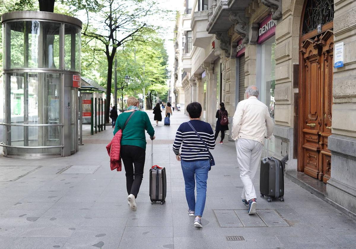 Turistas con sus maletas por la Gran Vía de Bilbao