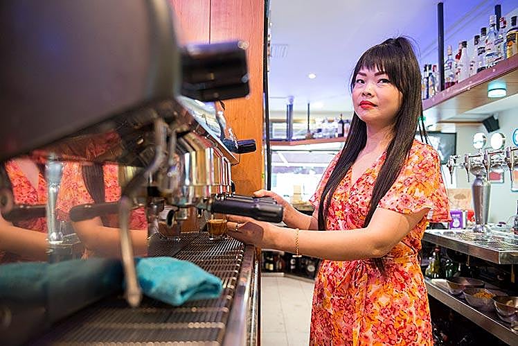 Lin nos atiende mientras sigue trabajando en su negocio hostelero.