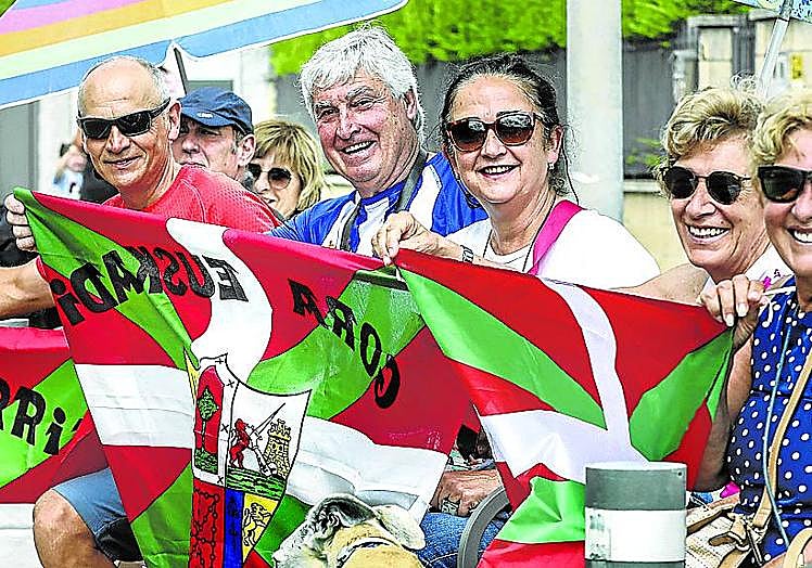 Imagen principal - La multitud ondeó las ikurriñas que se repartieron a granel por todo el recorrido. | Familias enteras animaron con pasión a los txirrindularis. | Largas colas para pasar por el photocall de EL CORREO como recuerdo de un día imborrable.