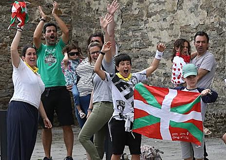 Imagen secundaria 1 - La multitud ondeó las ikurriñas que se repartieron a granel por todo el recorrido. | Familias enteras animaron con pasión a los txirrindularis. | Largas colas para pasar por el photocall de EL CORREO como recuerdo de un día imborrable.