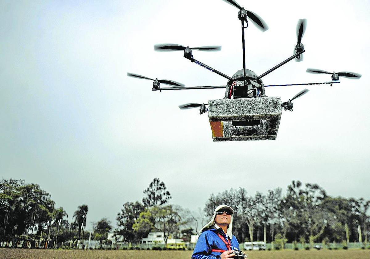 Un hombre pilota un dron para ejecutar trabajos agrícolas.