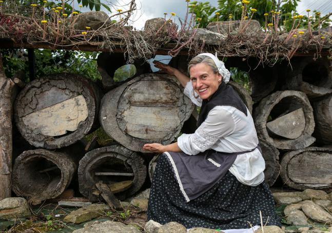 La pastora junto a varias de las colmenas de tronco que ha comprado para evitar que acabasen como leña.
