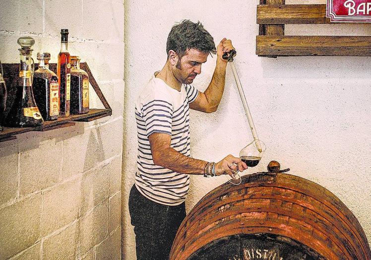 Gaizka Barañano extrae una muestra de vermú de una barrica de whisky escocés.