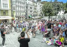 Cientos de personas frente a 'La Mirada' de Ibarrola para ver una actuación callejera.