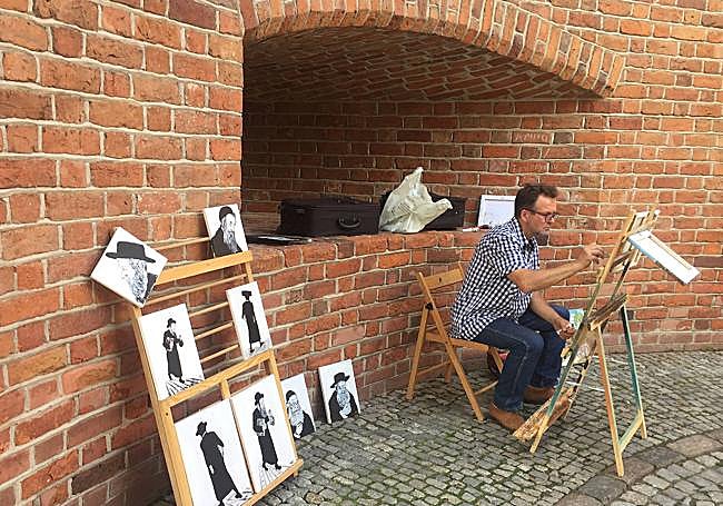 Un artista pinta imágenes de judíos en la muralla.