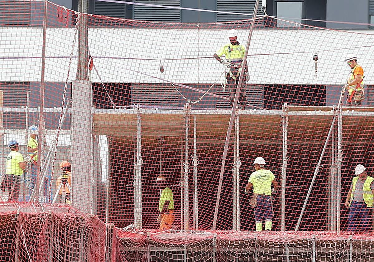Trabajadores de la construcción levantan un nuevo edificio de viviendas en un barrio de Bilbao.
