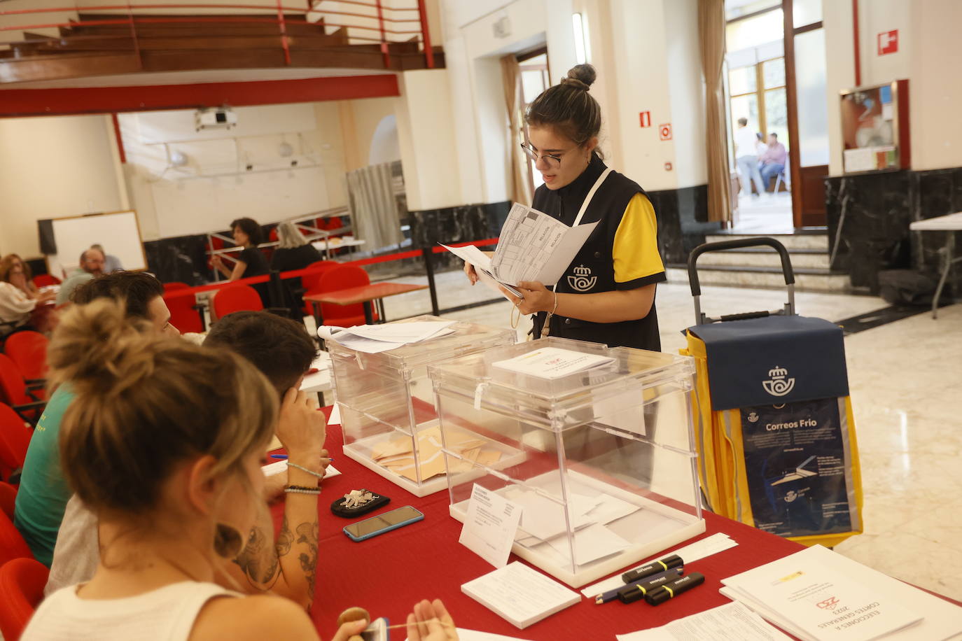 Una trabajadora de Correos se acerca al colegio del Centro de la Cultura de Portugalete para entregar el voto por correo.