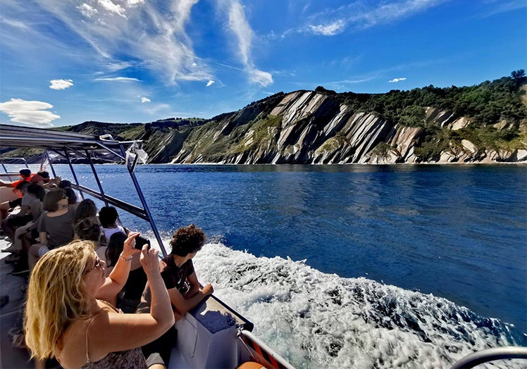 Un barco de Begi Bistan pasa junto al Flysch en Zumaia