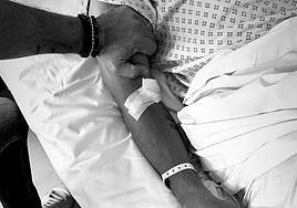 El Cholom Simeone agarra el brazo de su hijo en la cama del hospital.