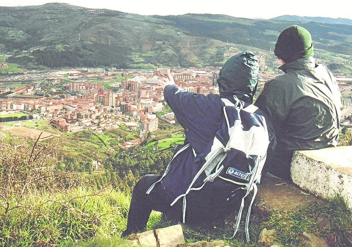 Dos montañeros escrutan el horizonte desde el castro del Malmasin.