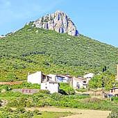 Naturaleza y arte. El caserío resguardado bajo Peña Unzué. A la derecha, pinturas murales cubren la cabecera de Santa María de Eristain.