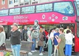 Visitantes foráneos toman un autobús turístico en Bilbao.