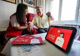 Joaquín Rodríguez ríe junto a Mertxe García, trabajadora social de Cruz Roja, que le suele atender por videoconferencia en el programa Etxean Bai.