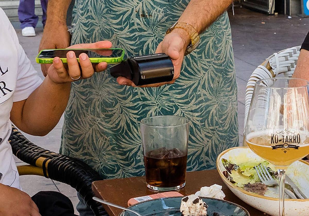 Un cliente abona su consumición a través de su teléfono.