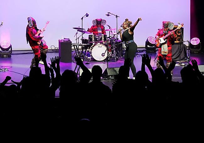 El público en pie ondeando las manos ante el cuarteto.