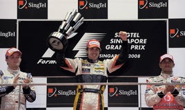 Fernando Alonso celebra en el podio su triunfo en el Gran Premio de Singapur de 2008.