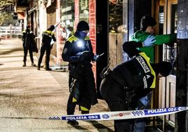 Un policía local cachea a un hombre en una calle de Vitoria.