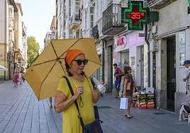 Una mujer se protege con un paraguas en Vitoria durante la ola de calor de agosto.