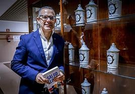 Gorka Orive delante de una vitrina con botes medicinales antiguos.