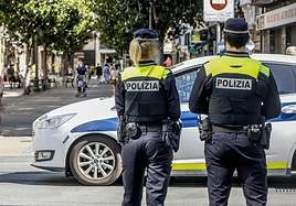 Policías locales, ajenos a la información, patrullan por una calle de Vitoria.