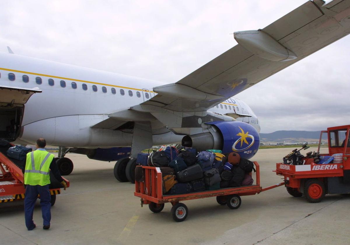 Operarios transportan el equipaje de un avión recién aterrizado a la terminal de Foronda.