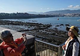 Dos mujeres se fotografían junto al muelle de Arriluze en Getxo.