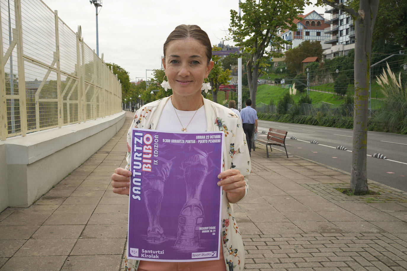 La edil de Deportes, Itziar Carrocera, muestra el cartel de la marcha a pie destinada a familias.